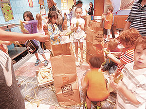 Corn shucking the old fashioned way, a great experience for kids learning about nutrition and health. ~Photo by Roxane Scrima. 