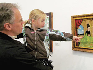 Four-year-old Vienna Reichert of Somerville checked out a painting at the Brickbottom Open Studios last weekend, accompanied by her dad Christopher.~Photo by Elizabeth Sheeran