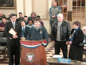 Arlington Catholic High School student John Richard, flanked by Alderman At Large Dennis M. Sullivan and his parents, received the praise and recognition by the entire Board of Aldermen for his outstanding achievements in sports. 