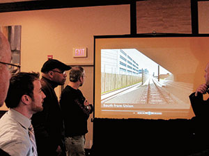 Attendees at the Green Line Extension meeting at the Holiday Inn last week viewed a 3D presentation depicting the Green Line route from Lechmere to Union Square stations. ~Photos by Douglas Yu