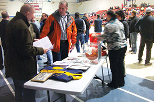 Friends of Lorne A. Murphy look over the display of memorabilia and memories on display during Friday’s ceremony, the highlight of which was the unveiling a banner in his honor.