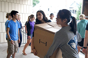 Tufts FOCUS student volunteers help unload and organize backpacks donated by United Stationers Charitable Foundation for the Back to School Backpack distribution event at the East Somerville Community School in late August.