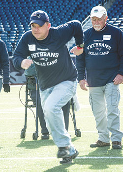 U.S. Army Veteran Frank Ellis sprints onto the field at Gillette Stadium for a running drill. He is joined by U.S. Air Force Veteran Paul O’Connor of Raynham, MA. 