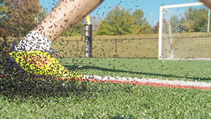 Crumb rubber sprays when artificial turf is struck with a falling ball, foot, or human. 