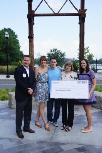 Assembly Row Vice President and General Manager Matt Ehrie presents check to the Foster family. Maureen Foster, Alex Foster’s mother, is holding the check.