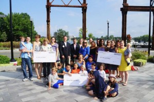 Assembly Row Vice President and General Manager Matt Ehrie presents checks to the Alex Foster Foundation (left), the On Stage Dance Company and Brooks Elementary PTO.