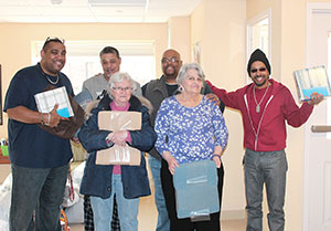 Capen Court volunteers, Peggy Kneeland and Pauline Ghiozzi, present sheets and blankets to veterans and staff at the Massachusetts Bay Veterans Center.