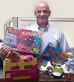 Michael McWilliams, Middlesex Federal Loan Officer and Somerville Kiwanis President, places his toy donation into the Middlesex Federal’s Davis Square Toys for Tots collection box.