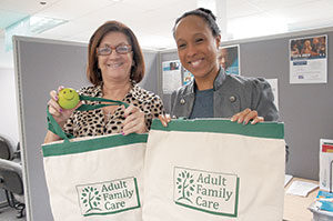 Jeanne Leyden (left) and Melissa Guevara display items from the caregiver appreciation packages that Adult Family Care is distributing as part of National Family Caregivers Month. The program serves more than 250 caregivers across the Greater Boston Area. ~ Photo by Nathan Lamb